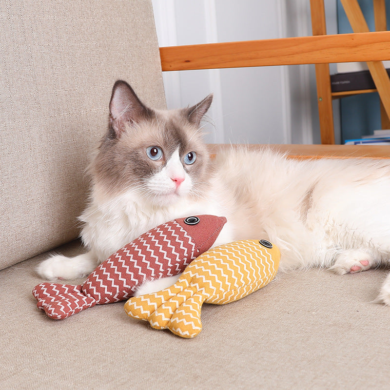 Interactive natural linen fish pillow cat toy resting on indoor floor