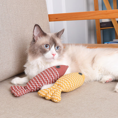 Interactive natural linen fish pillow cat toy resting on indoor floor