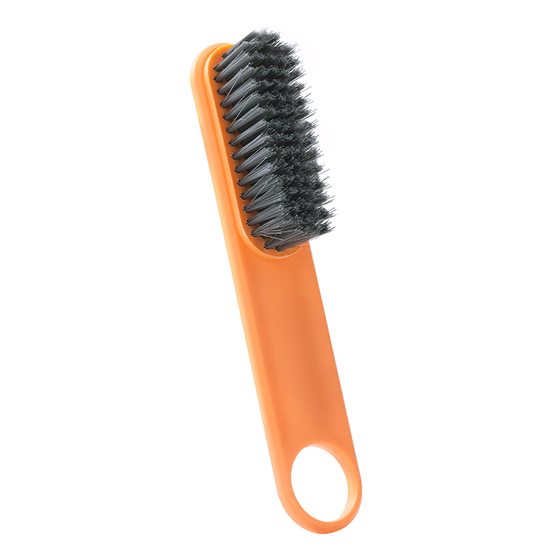 Yellow multifunctional soft bristle shoe cleaning brush resting on white surface